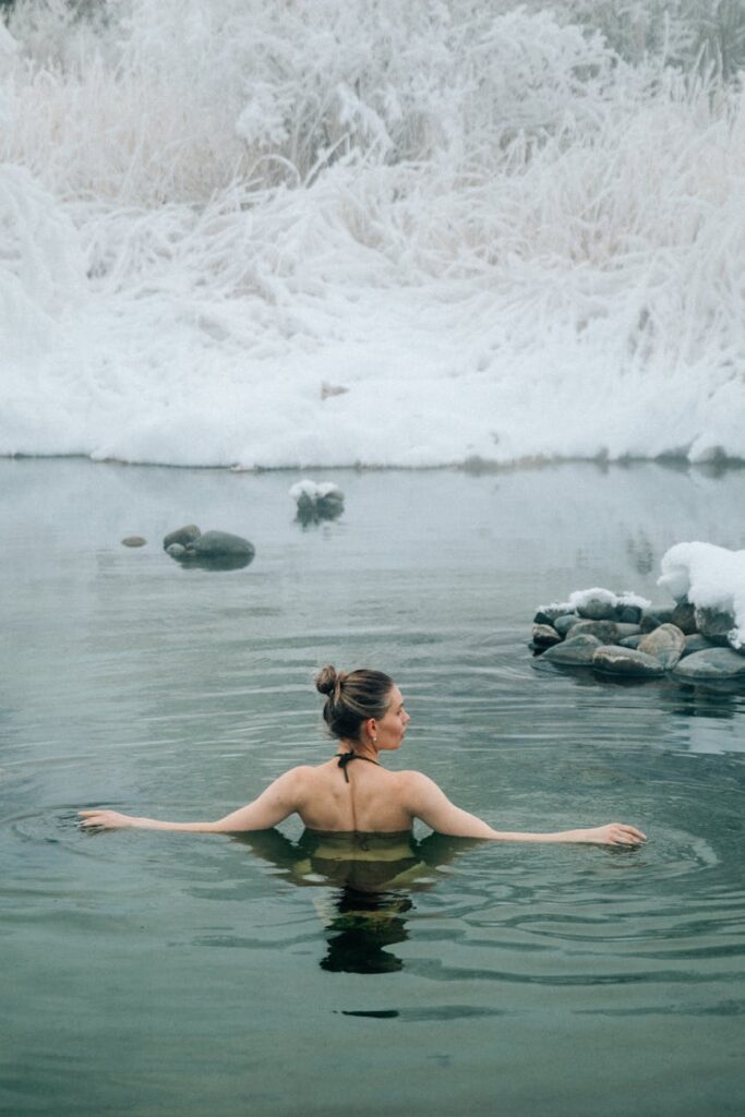 back of a young woman bathing in a winter lake