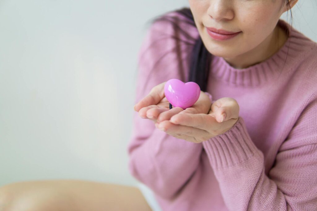 woman in purple sweater holding a toy heart